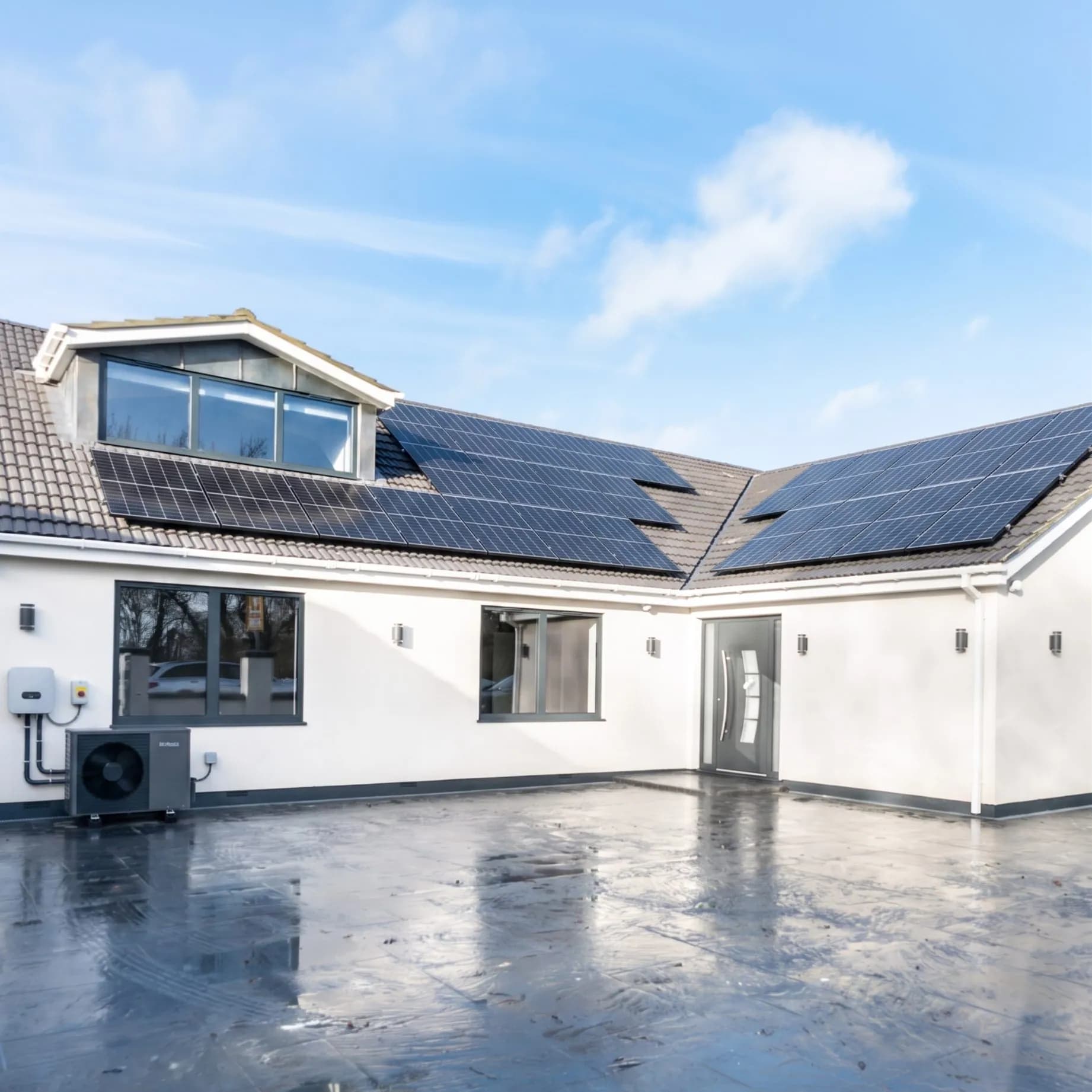 Full solar PV array and air source heat pump installed on a modern home in Essex